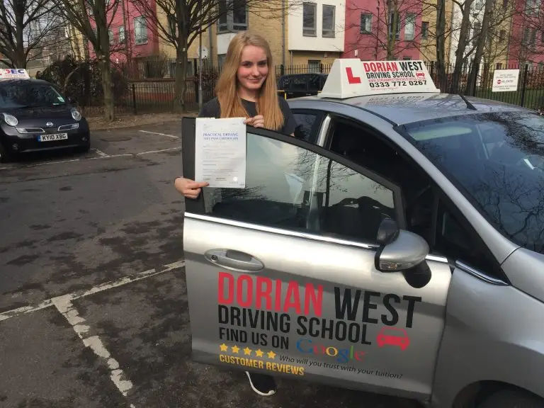 Dorian West with a learner driver beside a car after a driving lesson